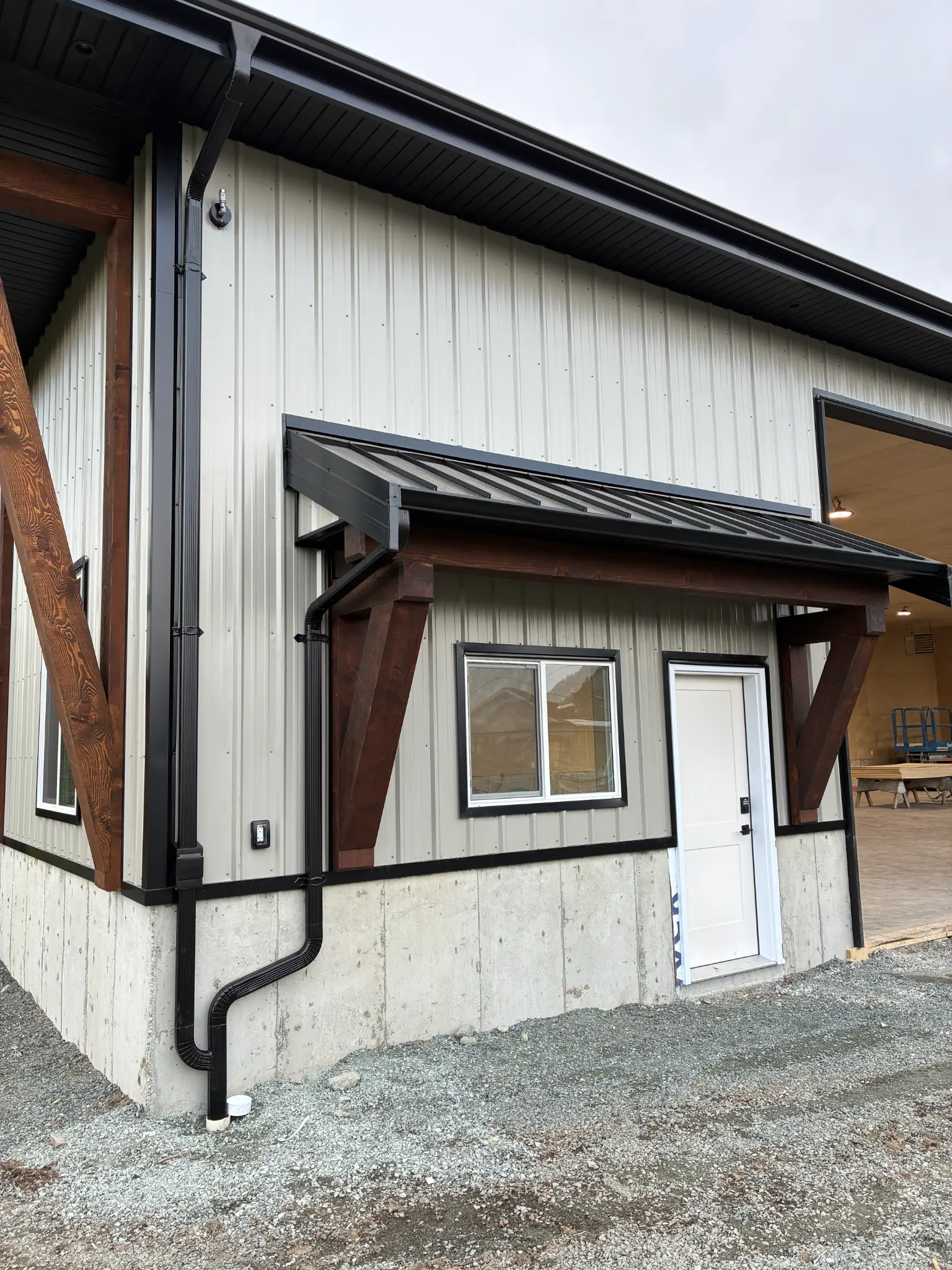 Close-up of black seamless gutter downspout on commercial building