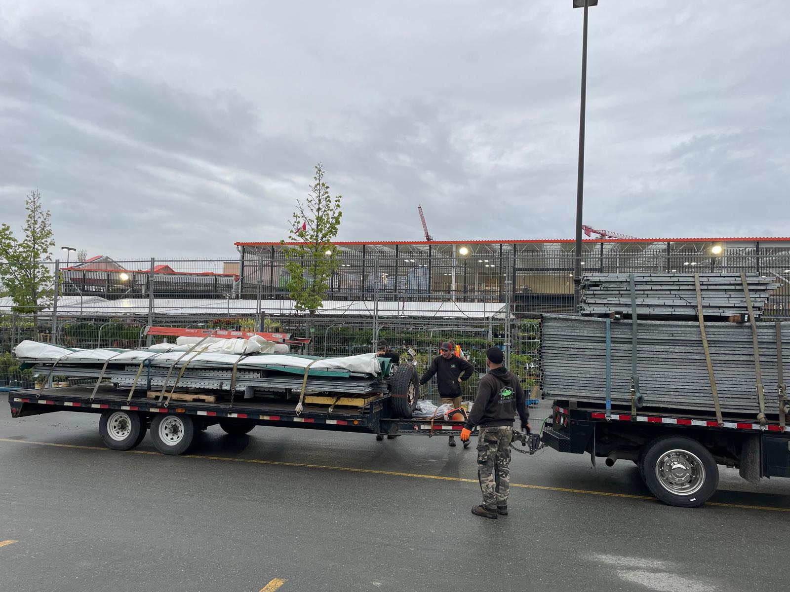 Crew loading materials onto flatbed trailers